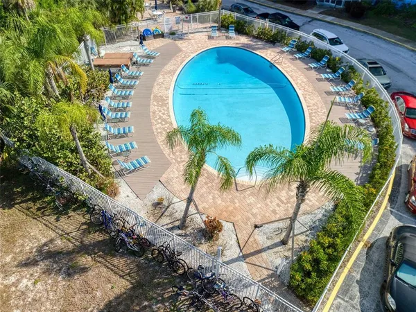 an aerial view of a swimming pool with outdoor seating
