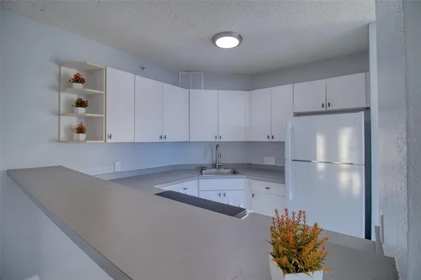 a kitchen with stainless steel appliances granite countertop a sink a refrigerator and a stove