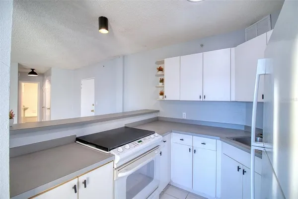 a kitchen with granite countertop white cabinets and white appliances