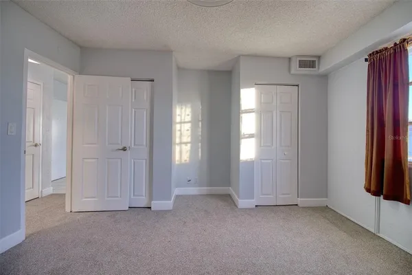 an empty room with windows and closet