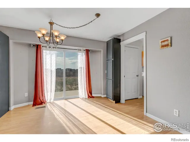 a view of a room with wooden floor and chandelier
