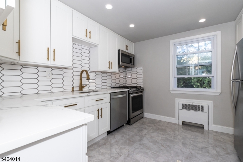 a kitchen with a stove a sink and a microwave