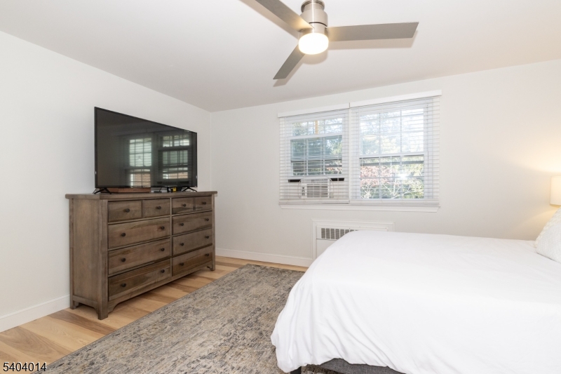 445 Morris Avenue Springfield, NJ 07081 - Photo 11 of 15 a bedroom with a bed and a flat tv screen on dresser