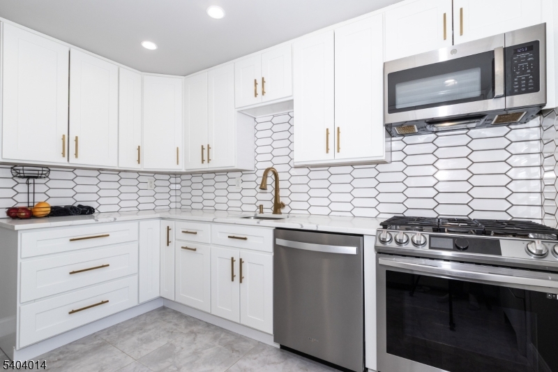 445 Morris Avenue Springfield, NJ 07081 - Photo 3 of 15 a kitchen with stainless steel appliances a stove sink and microwave