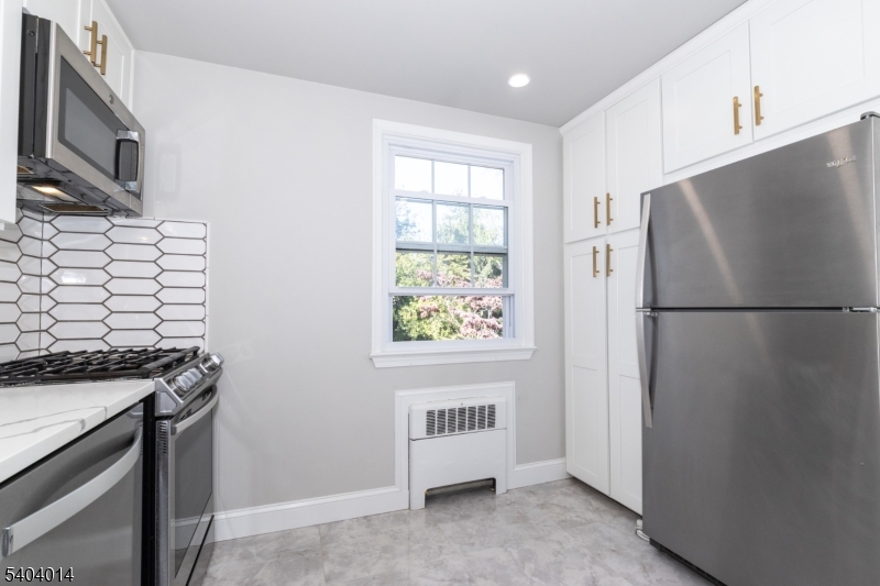 445 Morris Avenue Springfield, NJ 07081 - Photo 4 of 15 a kitchen with stainless steel appliances granite countertop a refrigerator a stove a sink and a window