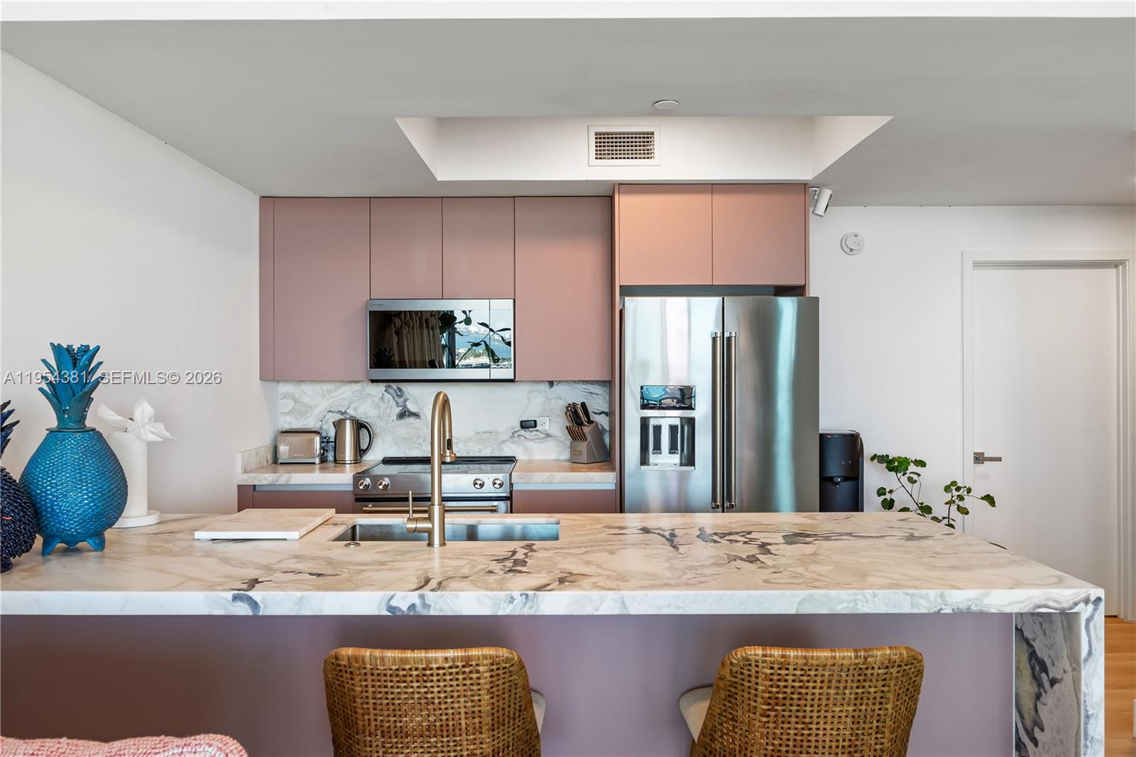 888 Biscayne Boulevard, Unit 2009 Miami, FL 33132 - Photo 5 of 21 a kitchen with kitchen island granite countertop a sink a counter top space and living room area