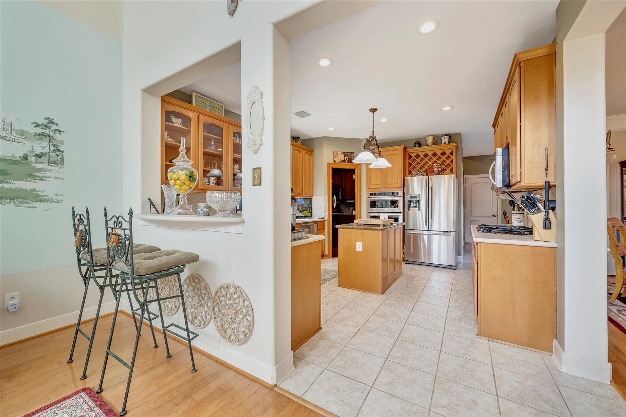 1639 Lakeside Enclave Drive Houston, TX 77077 - Photo 15 of 38 a kitchen with stainless steel appliances kitchen island granite countertop a refrigerator a stove a oven a sink a dining table and chairs with wooden floor