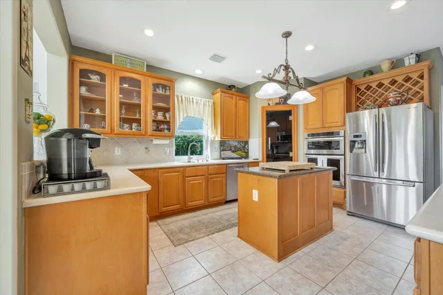 a kitchen with stainless steel appliances granite countertop a stove top oven a refrigerator a sink and dishwasher