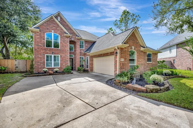a front view of a house with a yard and potted plants