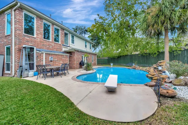 a view of a house with backyard swimming pool and sitting area
