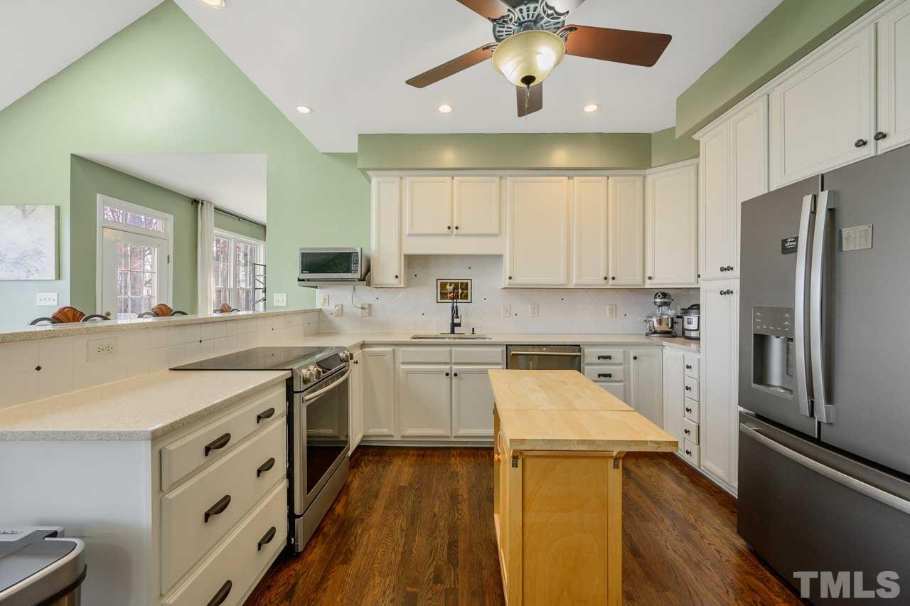 7001 New Sharon Church Road Rougemont, NC 27572 - Photo 8 of 52 a kitchen with stainless steel appliances a stove a sink dishwasher a refrigerator and white cabinets with wooden floor