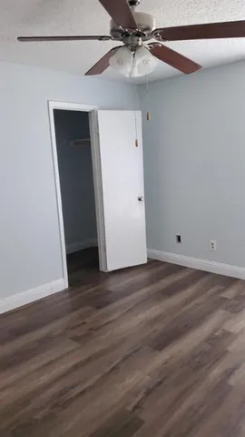 an empty room with a window and a ceiling fan