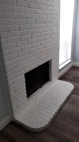 a room with a wooden floor and a fireplace