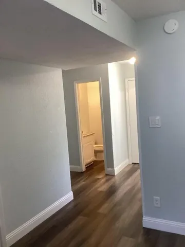 an empty room with wooden floor and closet