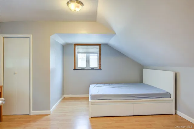 a living room with a bed and a potted plant
