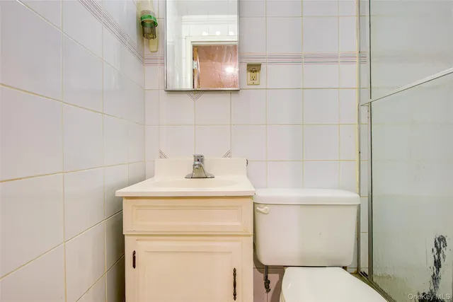 a bathroom with a toilet a sink and mirror