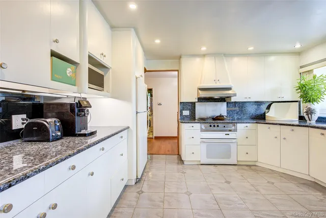 a kitchen with granite countertop a sink stove and refrigerator