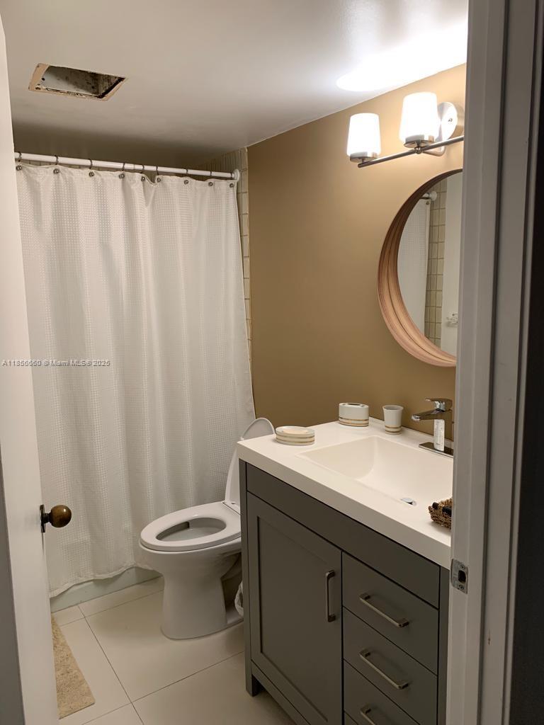 251 Crandon Boulevard, Unit 929 Key Biscayne, FL 33149 - Photo 16 of 26 a bathroom with a granite countertop sink toilet and a mirror