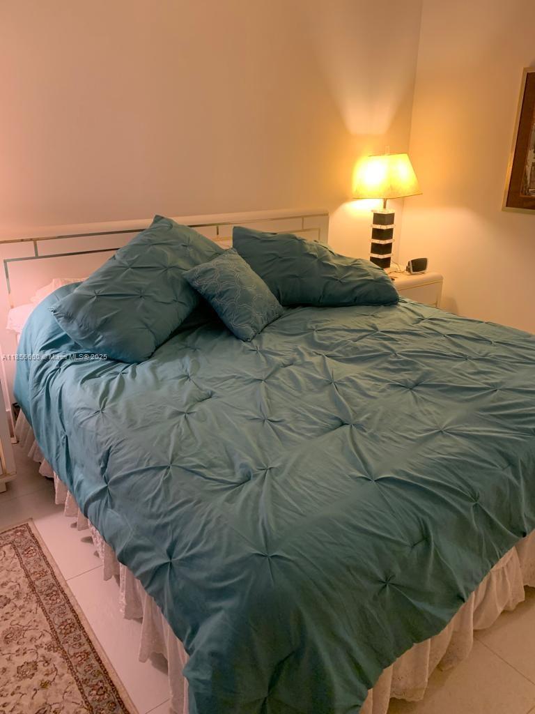 251 Crandon Boulevard, Unit 929 Key Biscayne, FL 33149 - Photo 18 of 26 a bedroom with a bed and a lamp