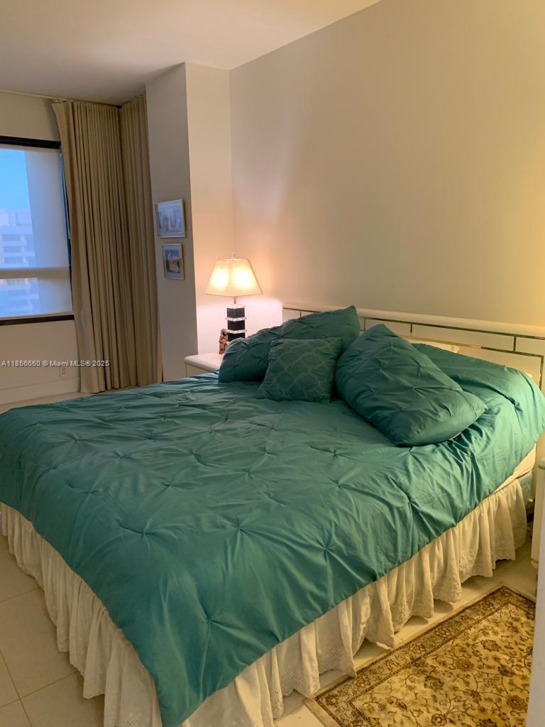 251 Crandon Boulevard, Unit 929 Key Biscayne, FL 33149 - Photo 19 of 26 a bedroom with a bed next to a window