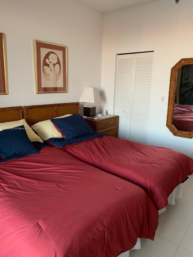 251 Crandon Boulevard, Unit 929 Key Biscayne, FL 33149 - Photo 22 of 26 a bedroom with a bed and cupboard