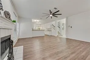 a view of an empty room with wooden floor and a fireplace