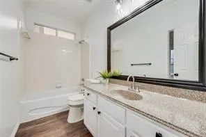 a bathroom with a granite countertop sink a toilet and a bathtub