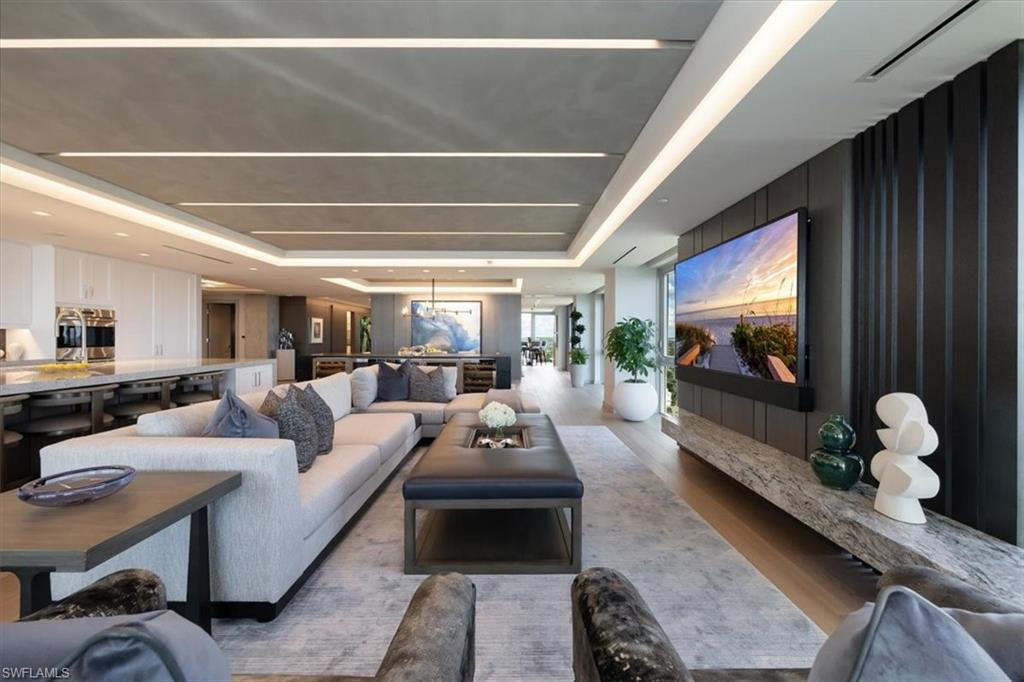 6897 Grenadier Boulevard, Unit 1701 Naples, FL 34108 - Photo 11 of 50 a living room with furniture and a flat screen tv