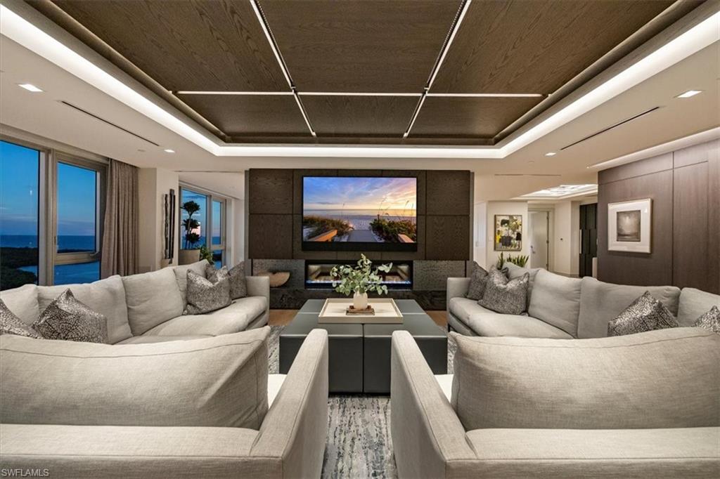 6897 Grenadier Boulevard, Unit 1701 Naples, FL 34108 - Photo 13 of 50 a living room with furniture and a flat screen tv