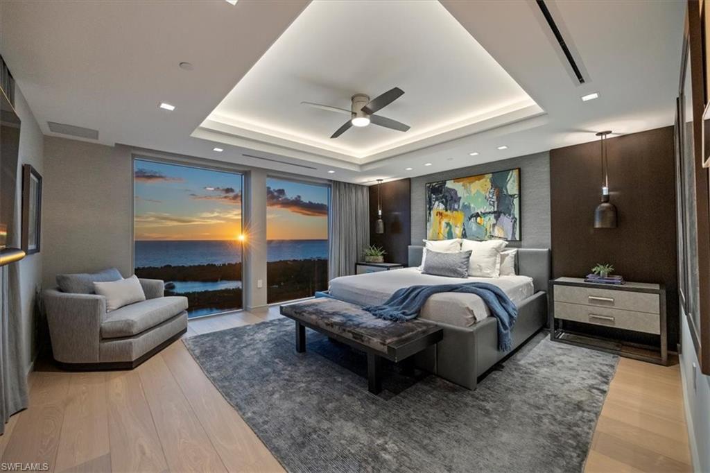 6897 Grenadier Boulevard, Unit 1701 Naples, FL 34108 - Photo 19 of 50 a spacious bedroom with a bed a couch and dresser