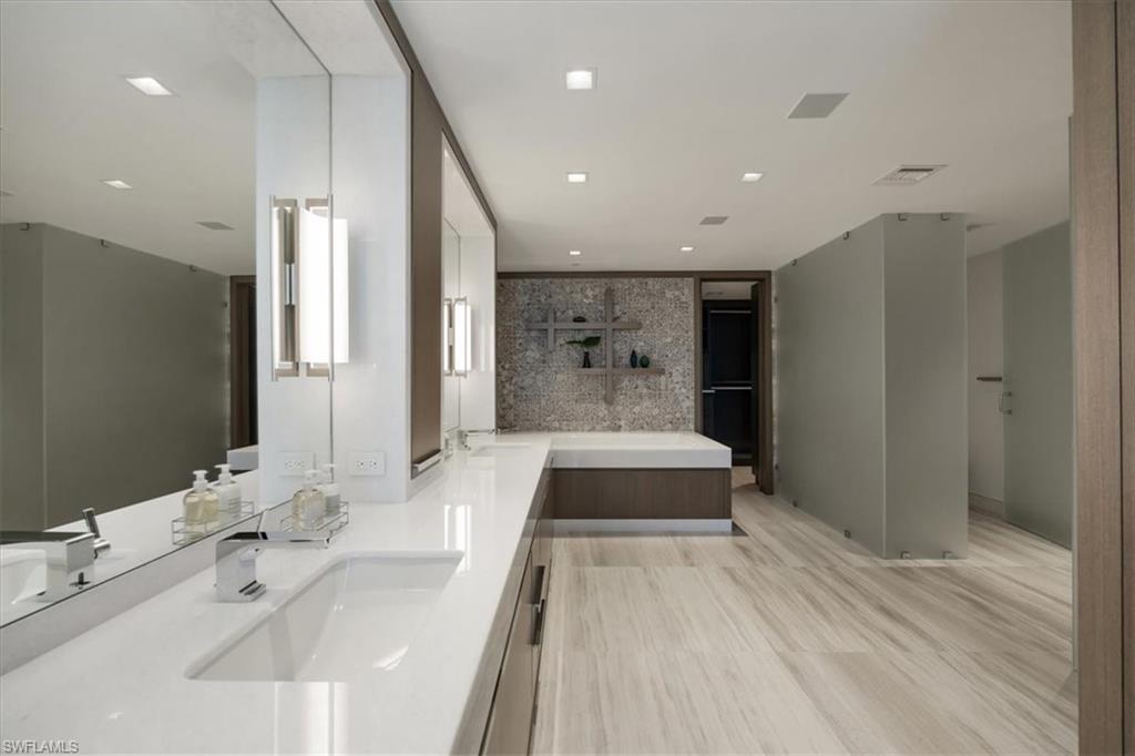 6897 Grenadier Boulevard, Unit 1701 Naples, FL 34108 - Photo 23 of 50 a spacious bathroom with a double vanity sink and a mirror