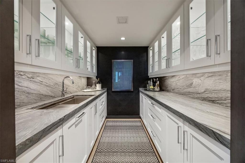 6897 Grenadier Boulevard, Unit 1701 Naples, FL 34108 - Photo 26 of 50 a kitchen with granite countertop sink stainless steel appliances and cabinets