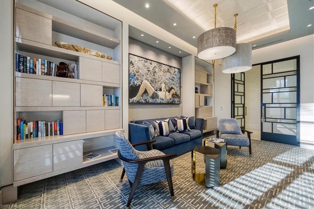 6897 Grenadier Boulevard, Unit 1701 Naples, FL 34108 - Photo 46 of 50 a living room with furniture and a book shelf