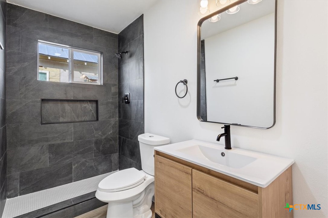 707 South 13th Street Temple, TX 76504 - Photo 20 of 24 a bathroom with a toilet sink and mirror