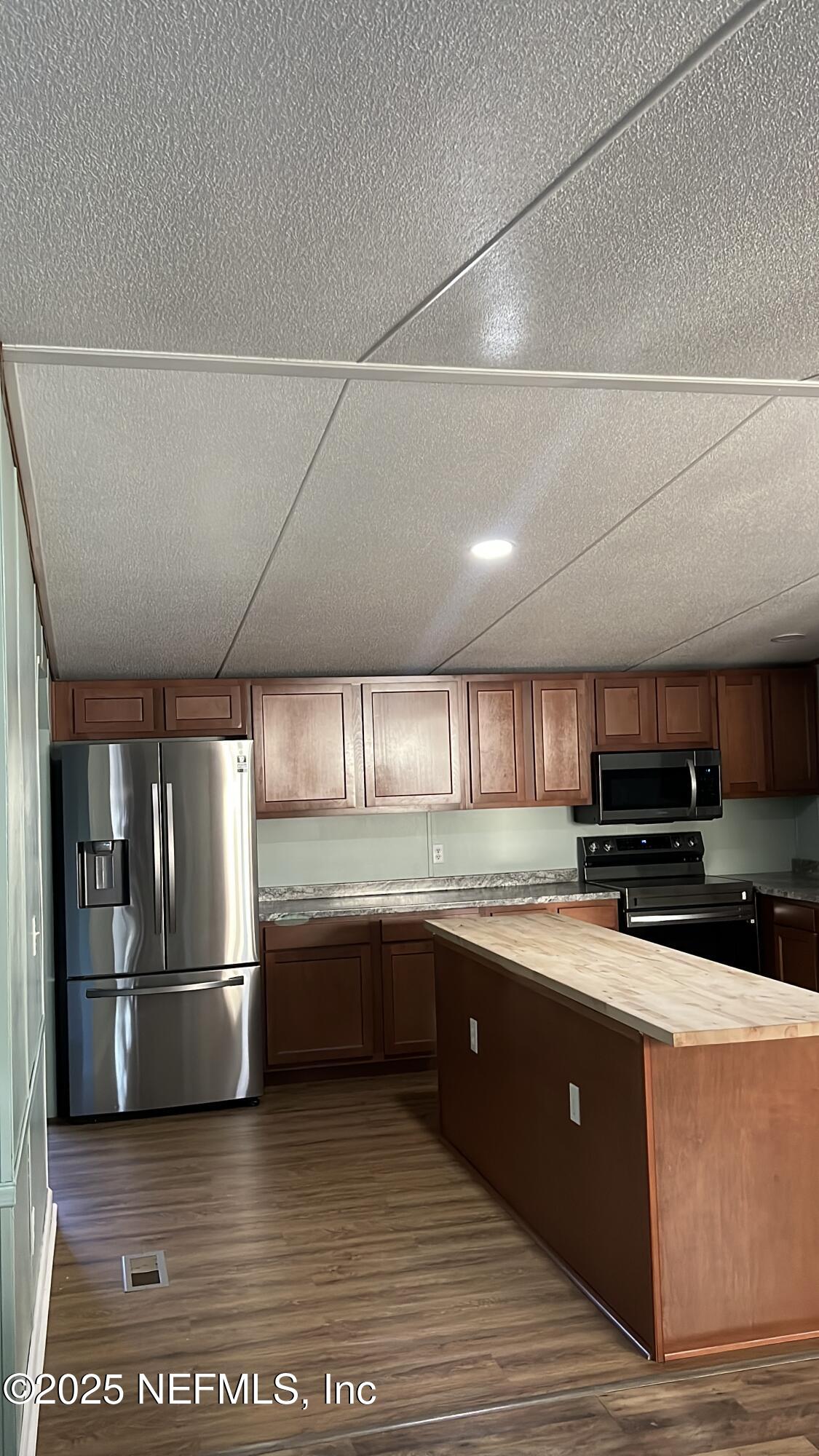 85182 Lonnie Crews Road Fernandina Beach, FL 32034 - Photo 2 of 15 a large kitchen with stainless steel appliances wooden cabinets and a sink