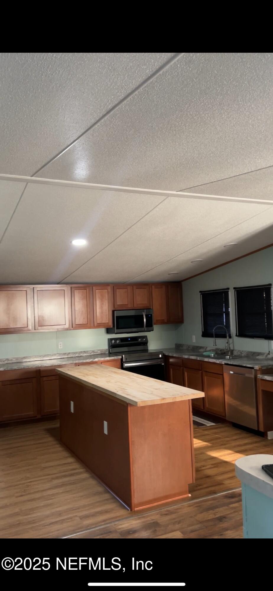 85182 Lonnie Crews Road Fernandina Beach, FL 32034 - Photo 3 of 15 a kitchen with stainless steel appliances granite countertop a sink and a microwave