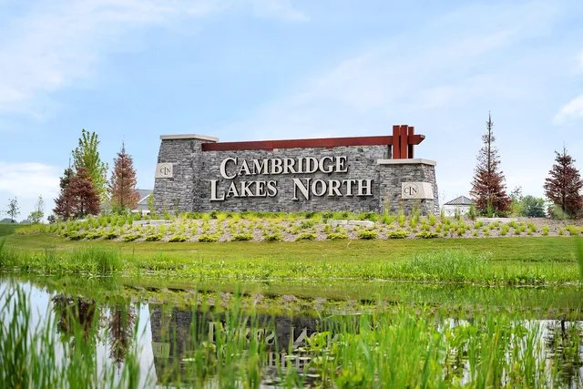 a sign of golf club on a wall under a large tree
