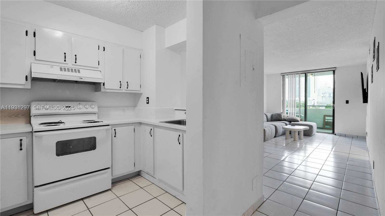 546 Southwest 1st Street, Unit 603 Miami, FL 33130 - Photo 4 of 14 a kitchen with white cabinets and white appliances