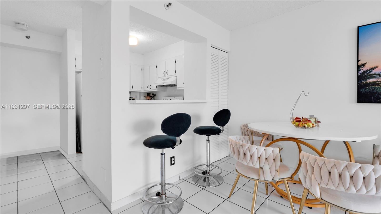 546 Southwest 1st Street, Unit 603 Miami, FL 33130 - Photo 7 of 14 a kitchen with a dining table chairs and white cabinets