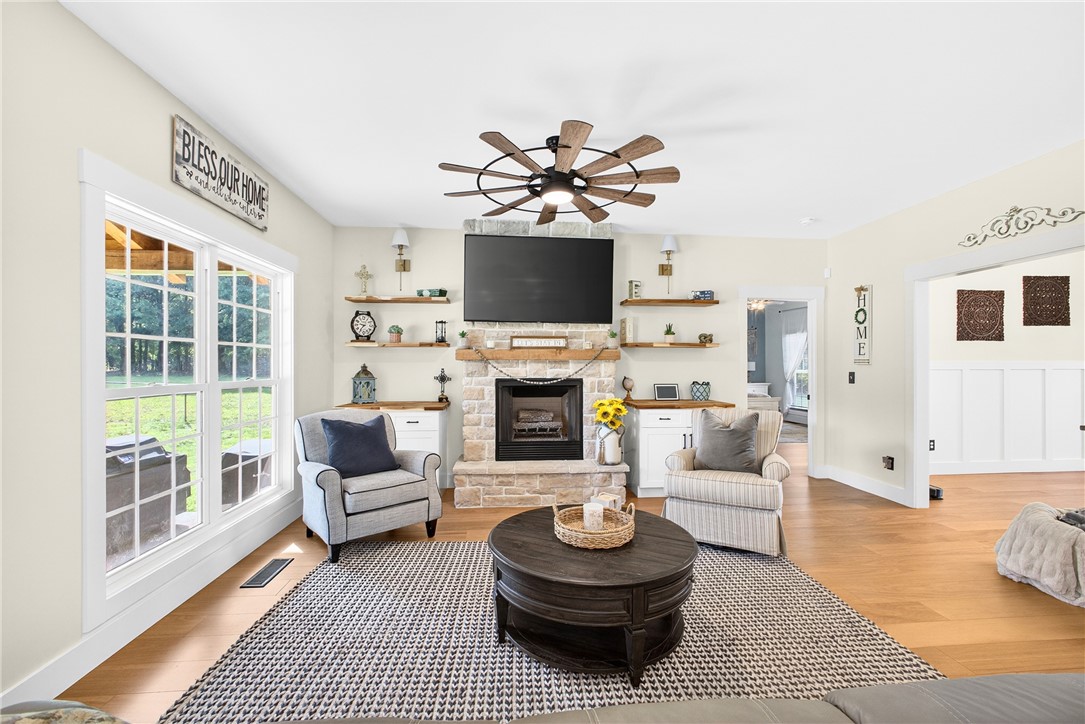 5016 Copeland Road Belton, SC 29627 - Photo 14 of 45 A comforting living area with a stone fireplace and rich hardwood flooring invites relaxation.