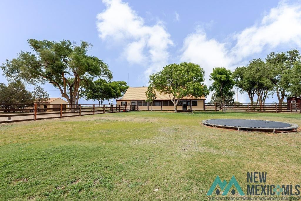 1131 Curry Road North Clovis, NM 88101 - Photo 40 of 69 Expansive green lawn area featuring a perimeter fence and mature trees