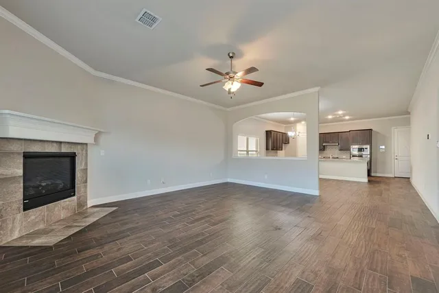 a view of an empty room with a fireplace and a window