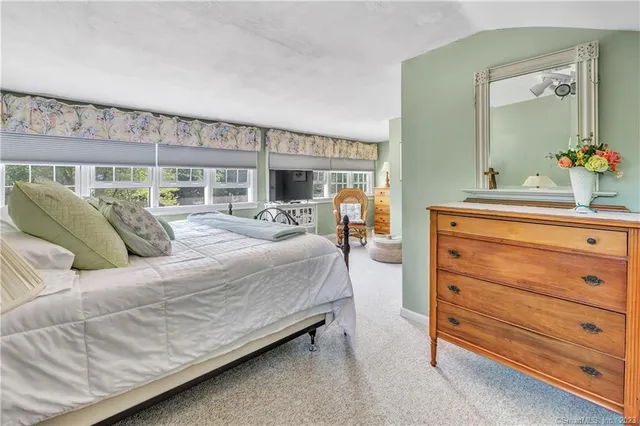 a bedroom with a bed and large windows