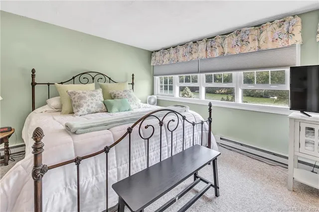 a bedroom with a bed next to a window