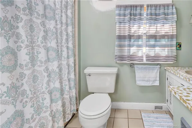 a bathroom with a toilet and a shower curtain