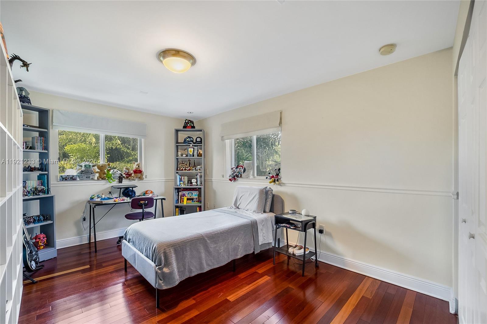 10670 Southwest 77th Avenue, Unit 10670 Pinecrest, FL 33156 - Photo 16 of 28 a bedroom with a bed and a bookshelf with wooden floor