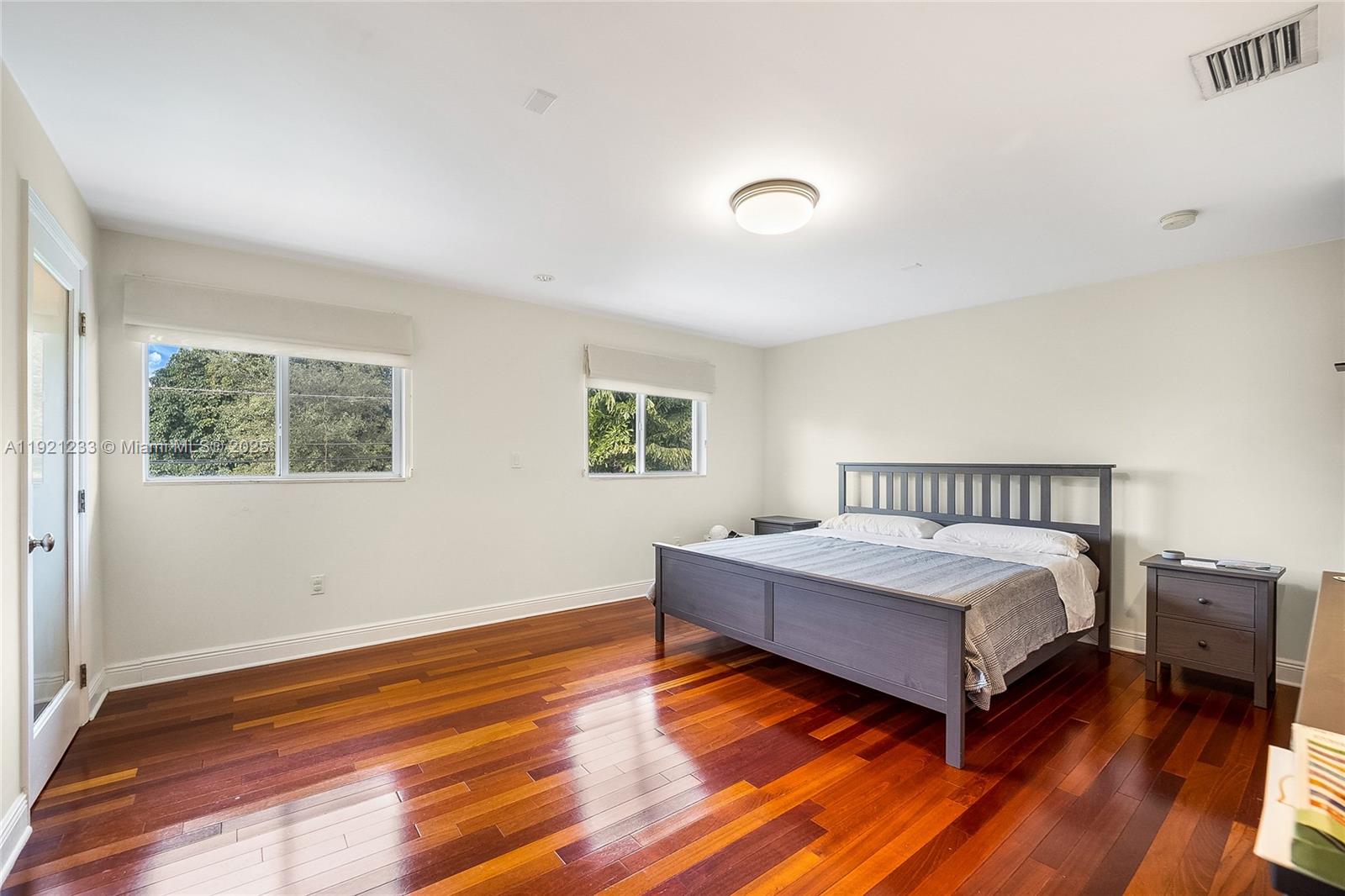 10670 Southwest 77th Avenue, Unit 10670 Pinecrest, FL 33156 - Photo 20 of 28 a spacious bedroom with a bed and wooden floor