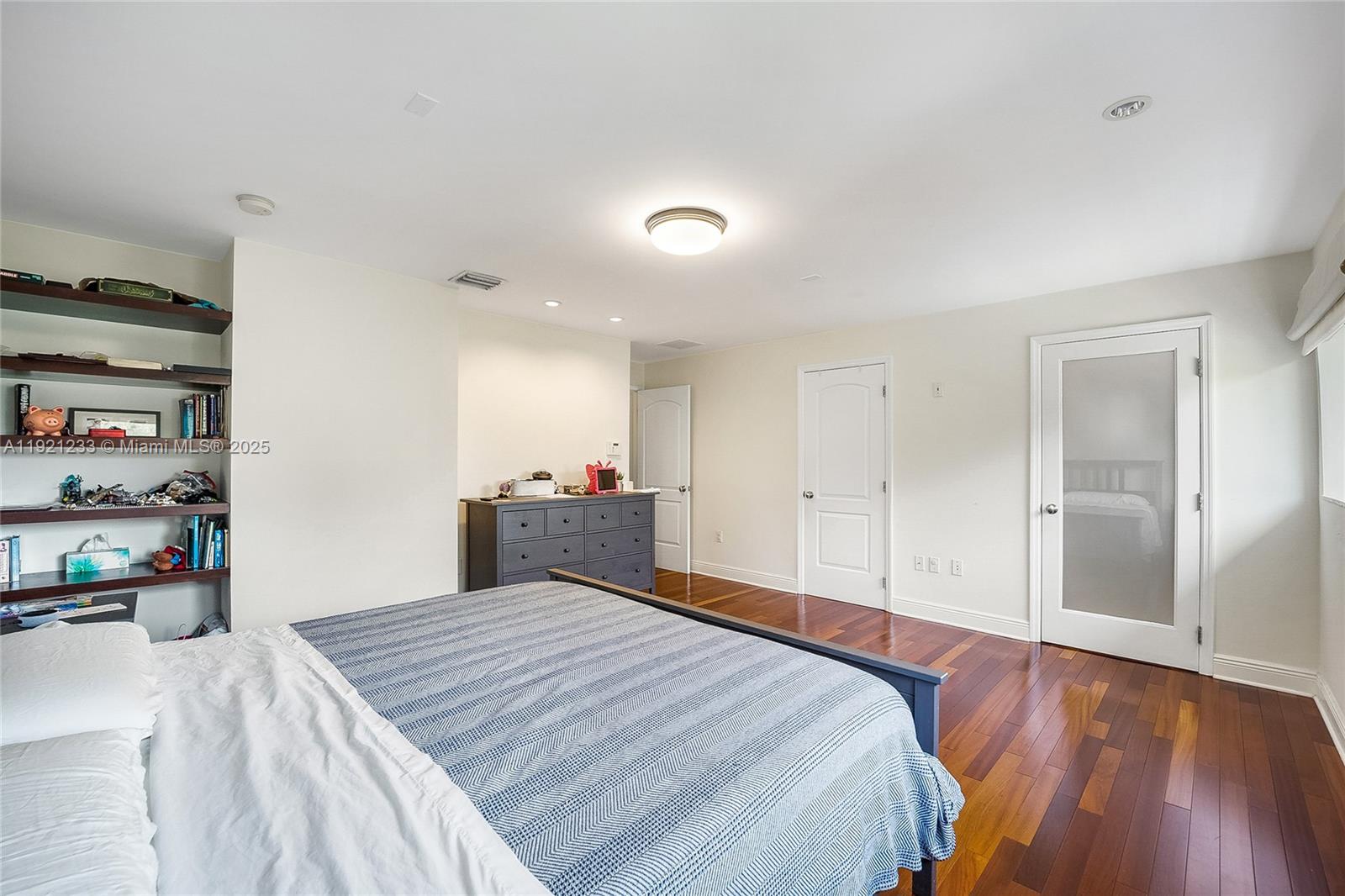 10670 Southwest 77th Avenue, Unit 10670 Pinecrest, FL 33156 - Photo 21 of 28 a bed room with a bed and a book shelf