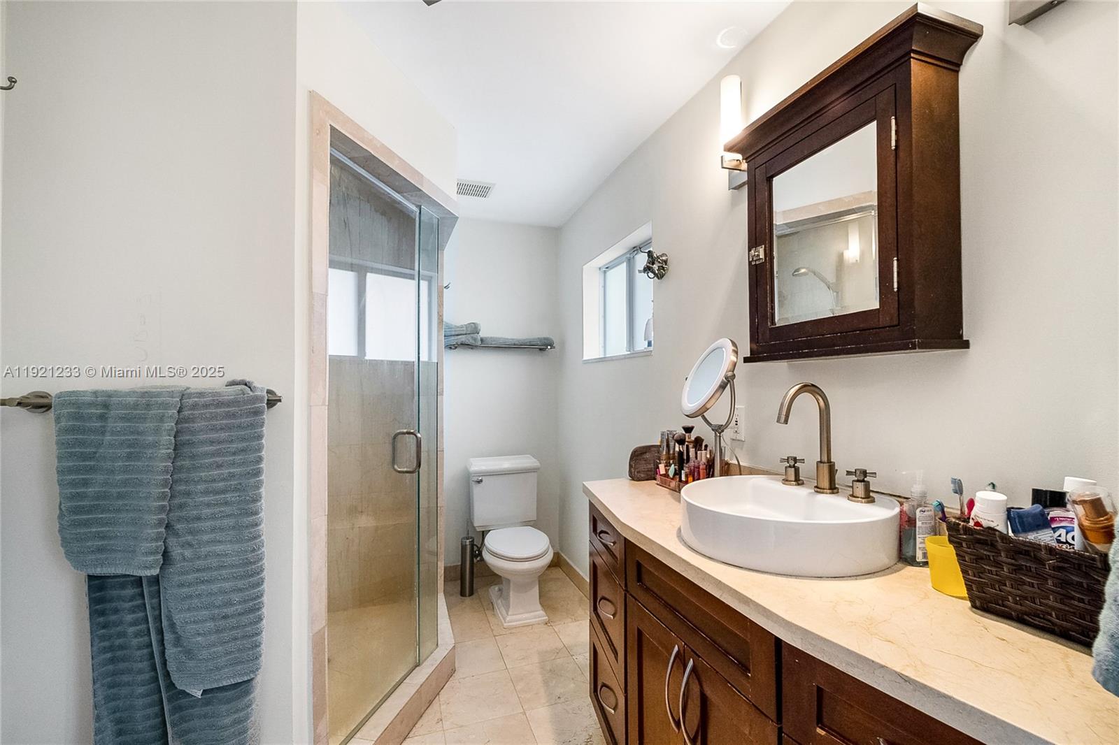 10670 Southwest 77th Avenue, Unit 10670 Pinecrest, FL 33156 - Photo 23 of 28 a bathroom with a sink a toilet and mirror
