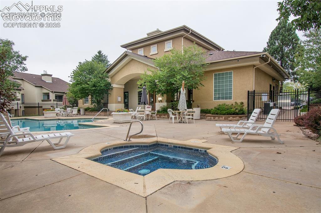 3715 Riviera Grove, Unit 101 Colorado Springs, CO 80922 - Photo 2 of 36 Outdoor amenity area featuring a swimming pool, integrated spa, and concrete decking